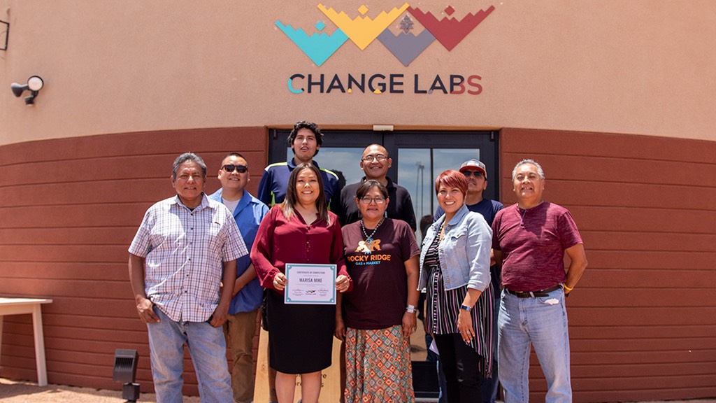 a group of people standing in front of a building that says change labs.