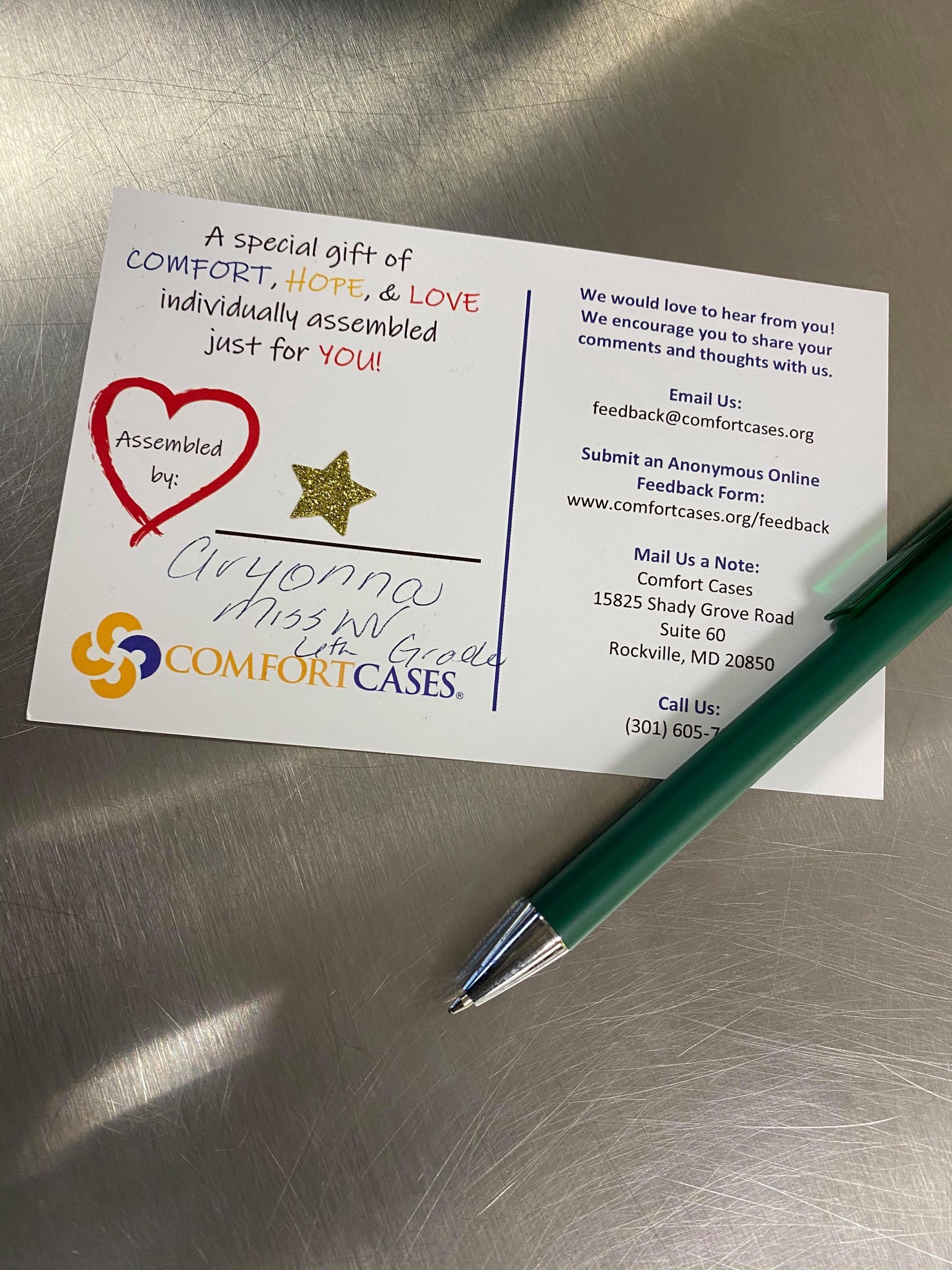 a card with a pen and a heart on it.