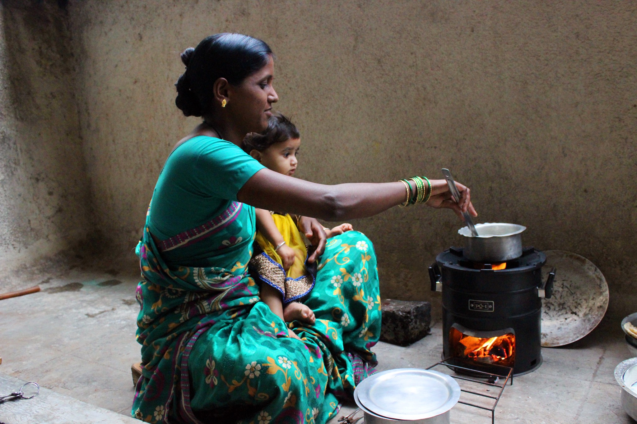 a woman in a sari cooking on a stove.
