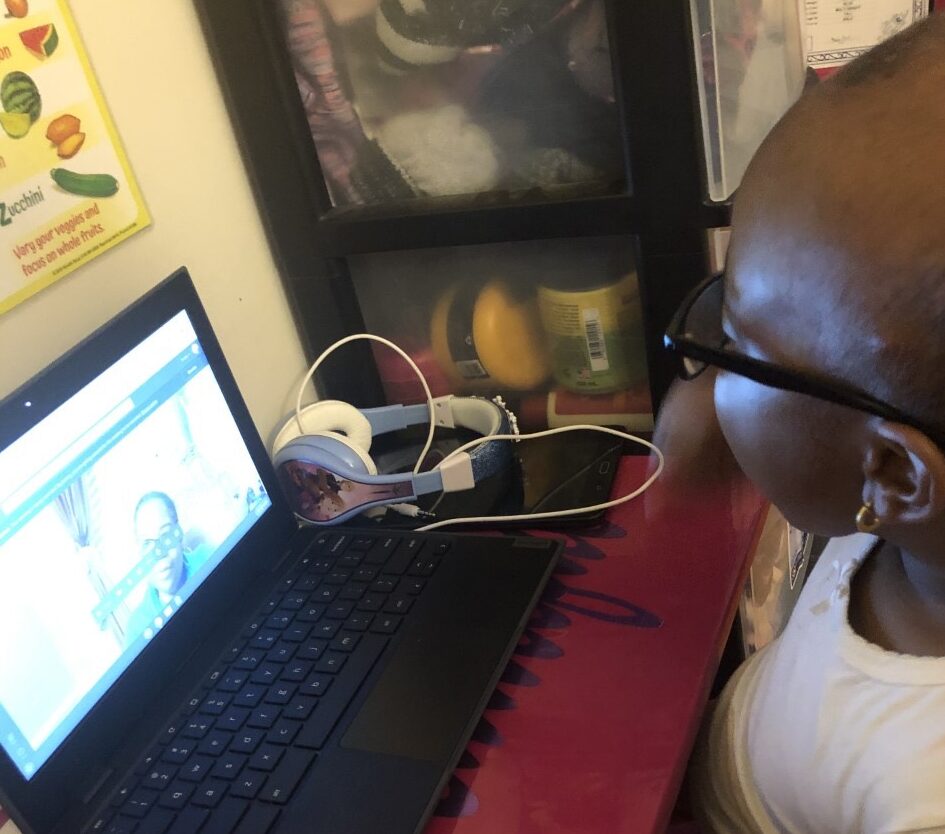 a little girl is watching a video on a laptop.