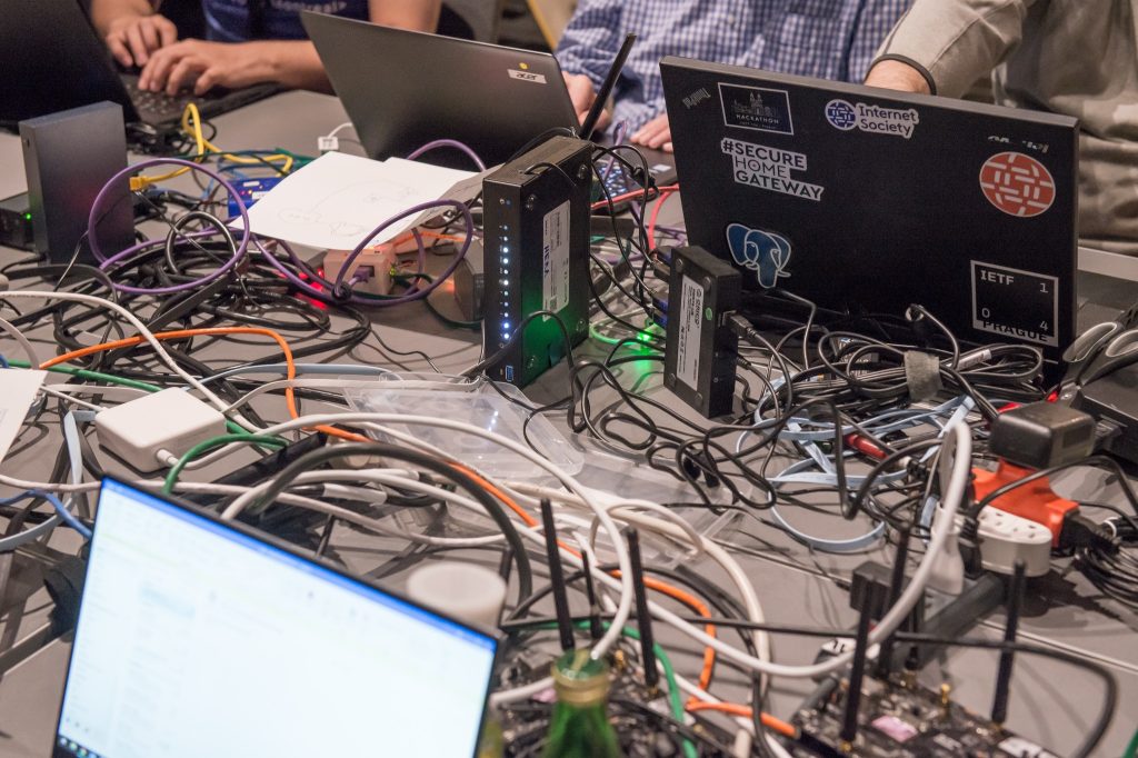 a group of people sitting around a table with laptops.