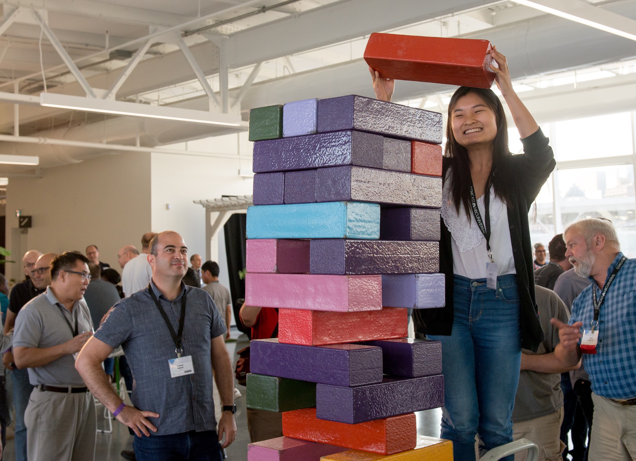 a woman standing on top of a stack of colorful blocks.