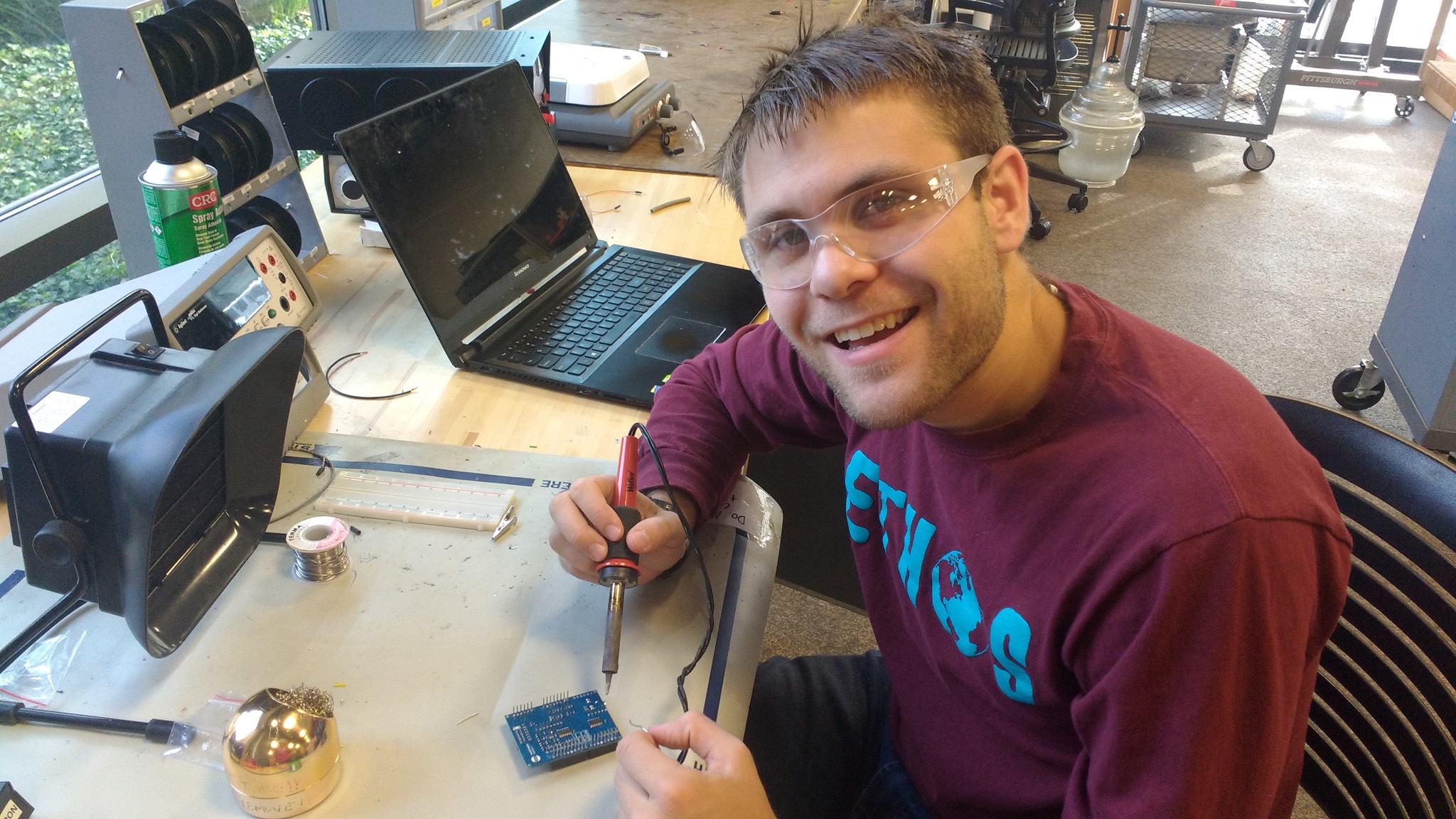 a man smiling while working on a computer.