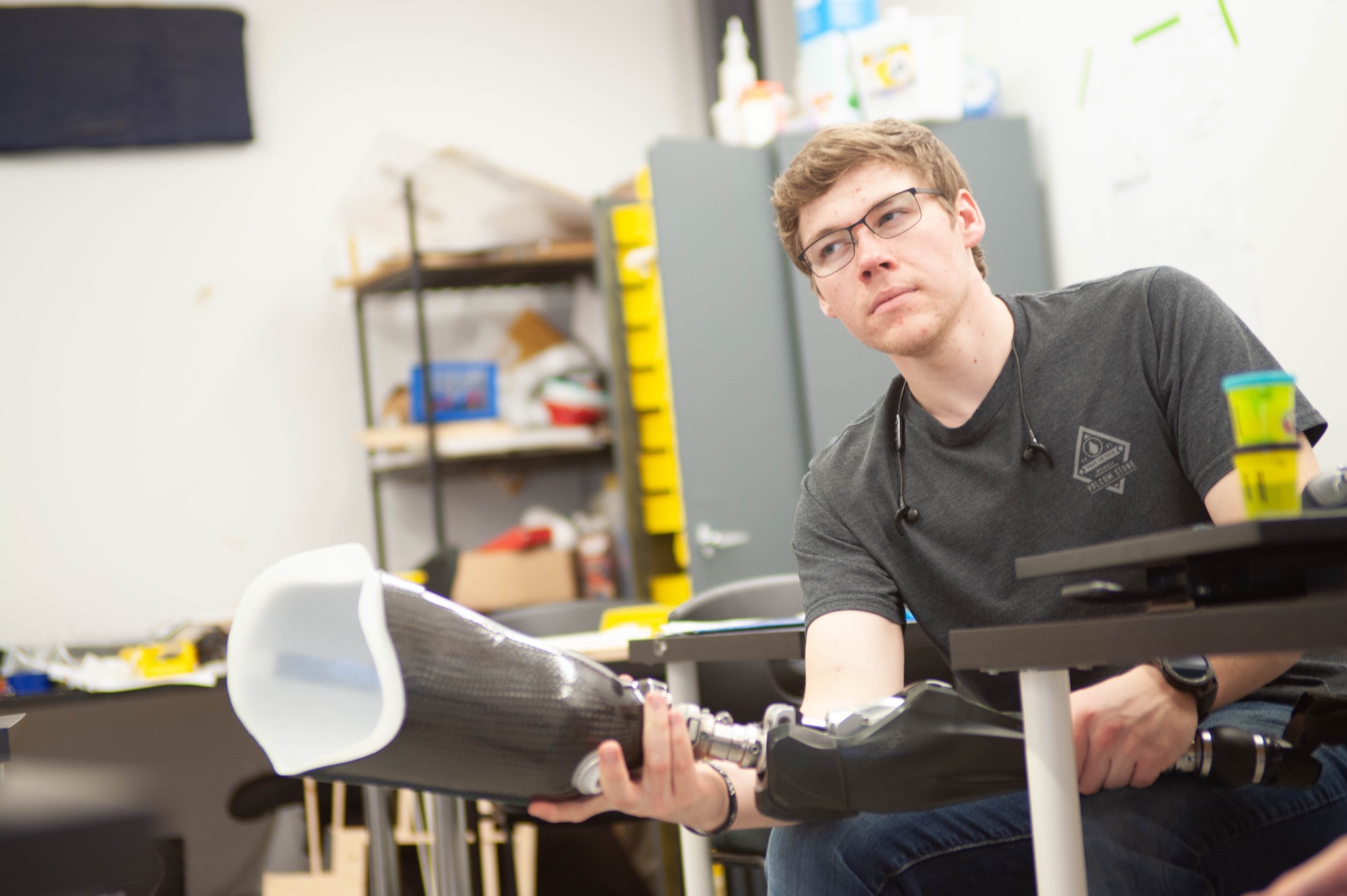a man with glasses sitting at a desk.