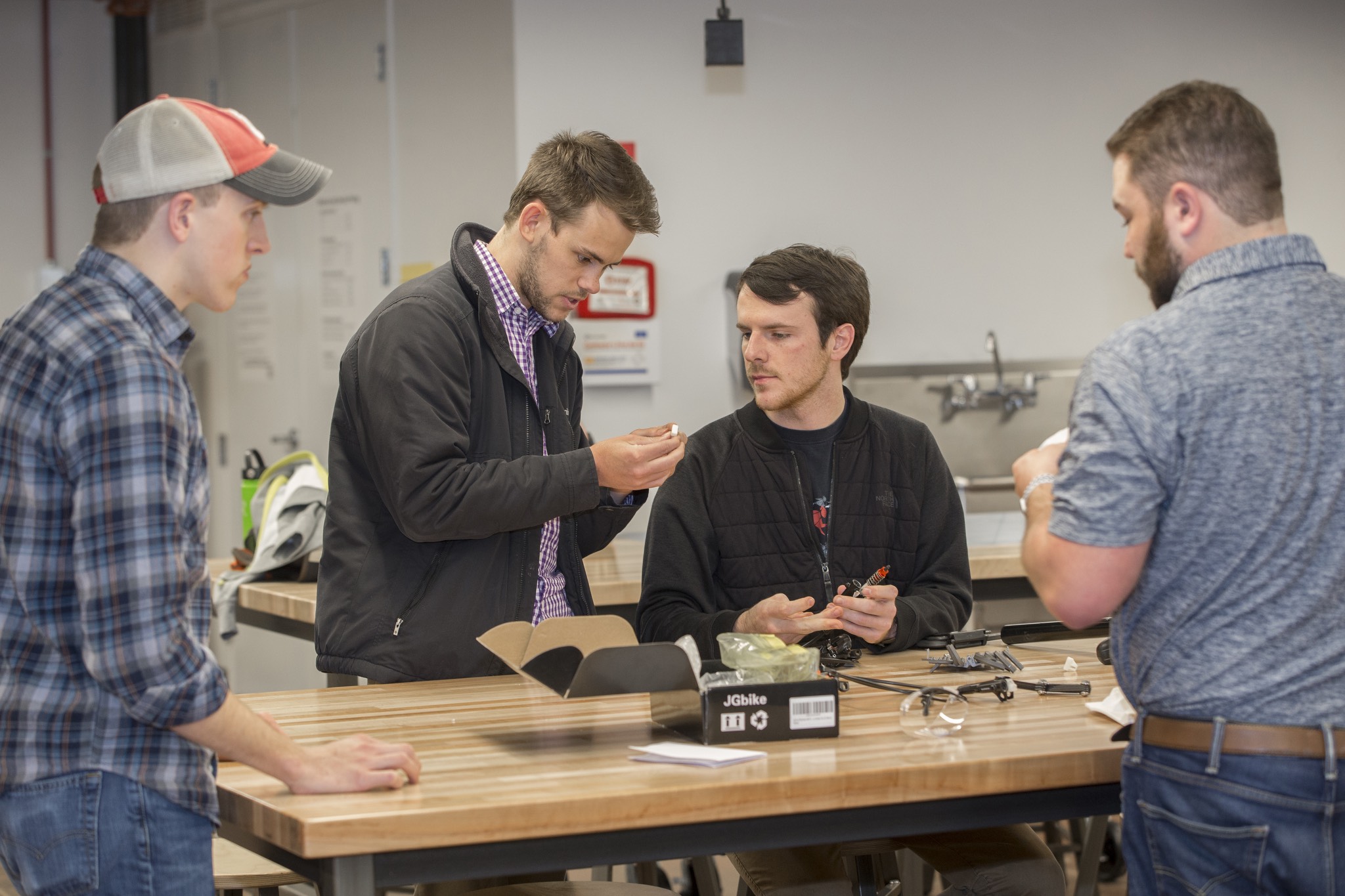 a group of men standing around a table.
