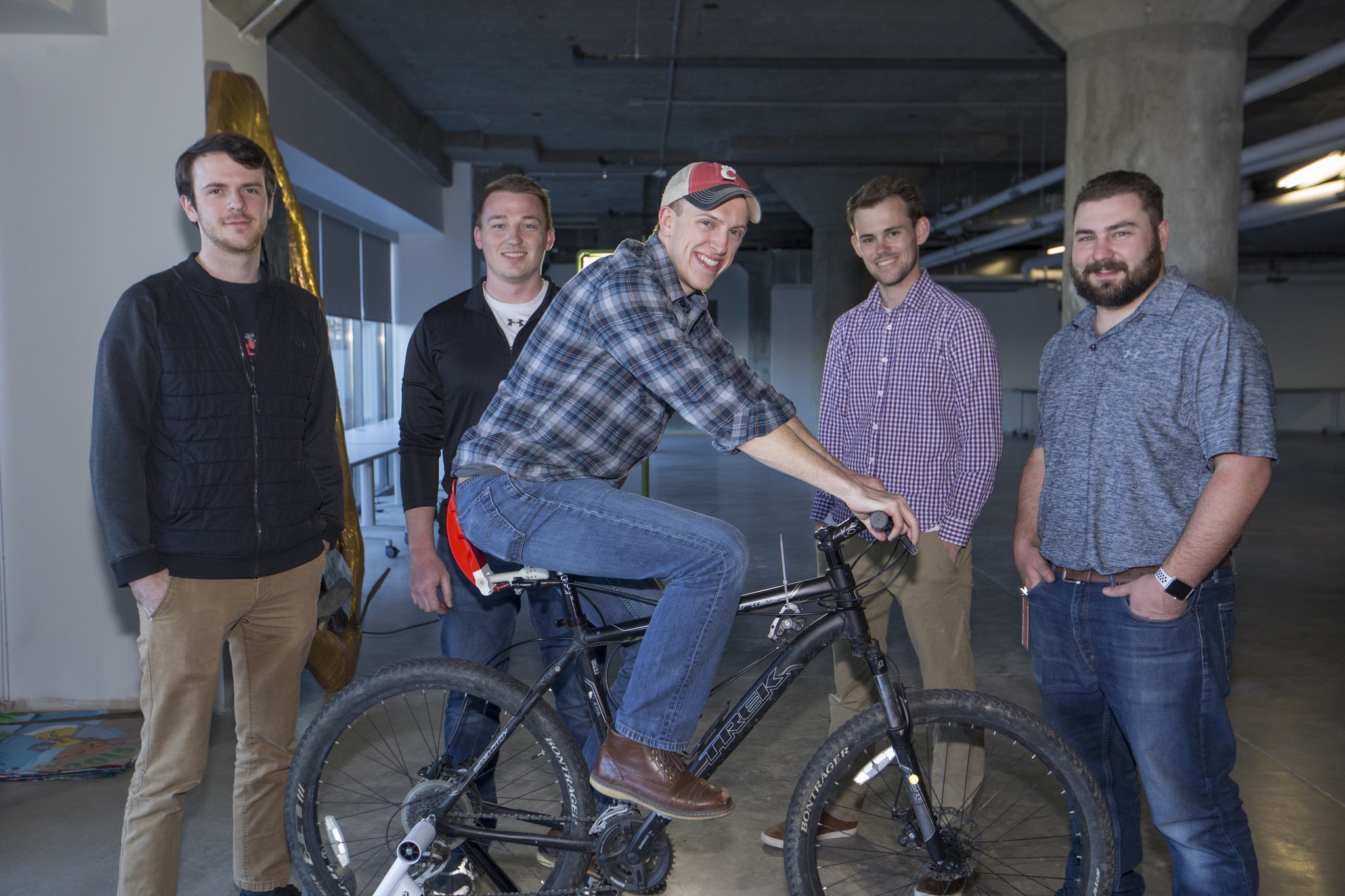 a group of men standing next to a bicycle.