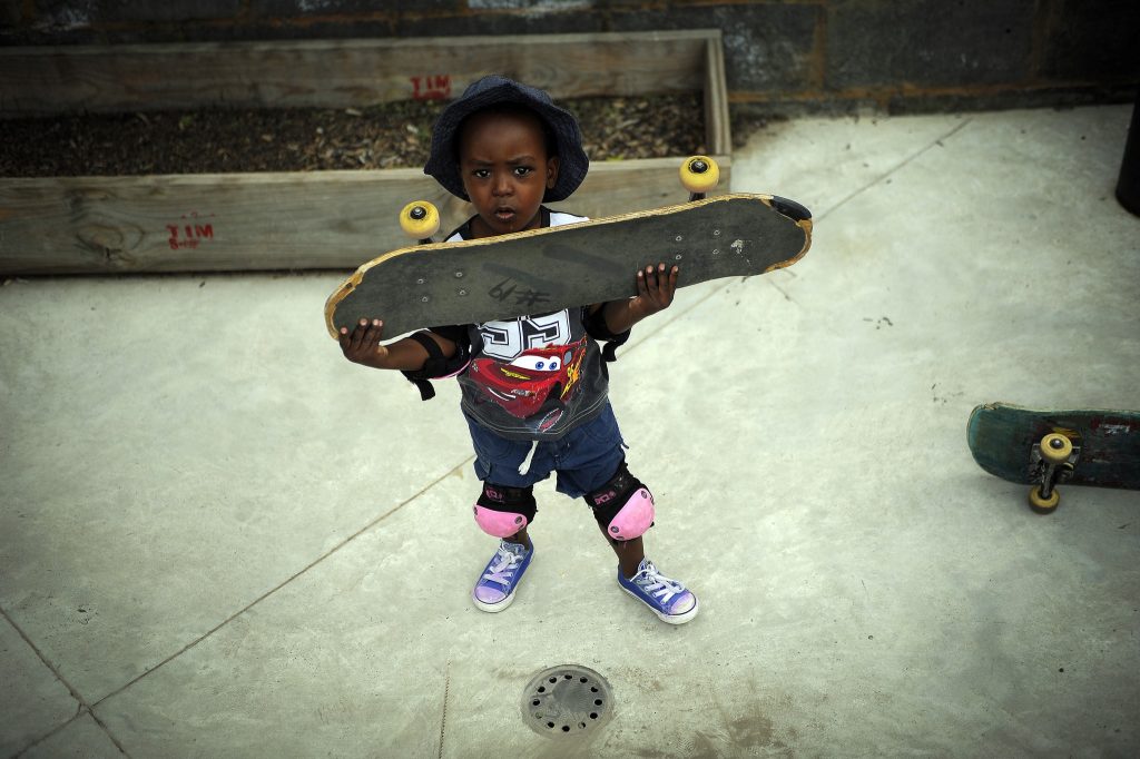 a young boy holding a skateboard.