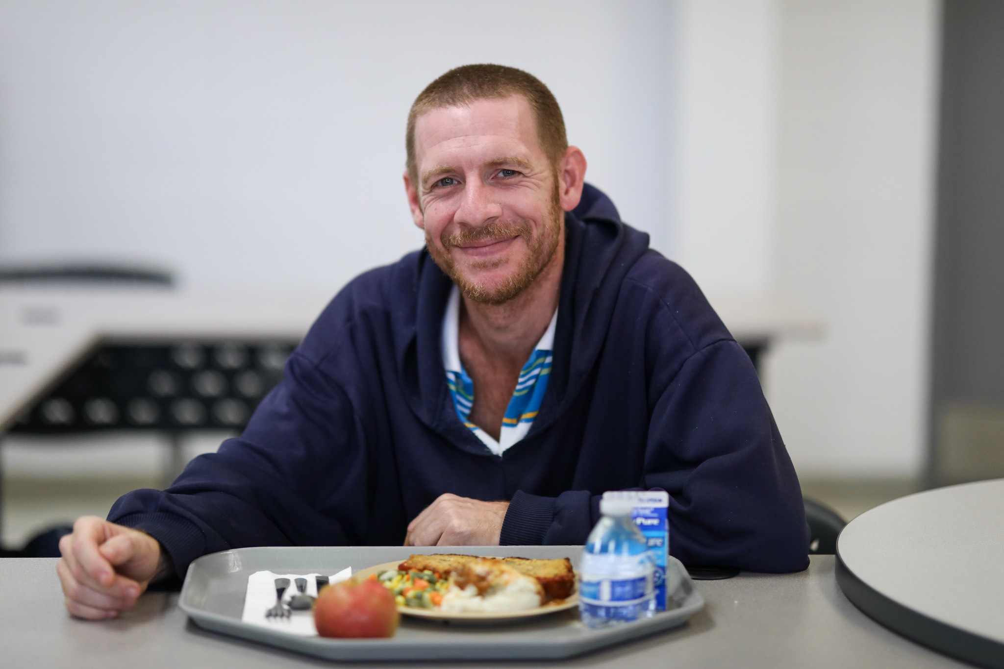 a man sitting at a table with a plate of food.