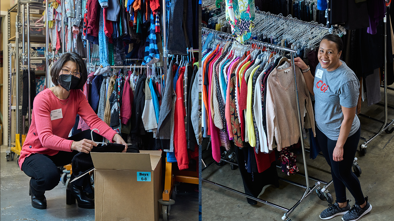 two women working in a warehouse with clothes on racks.